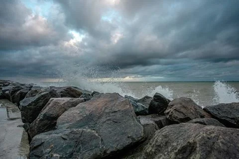 Dramatic sky over the black sea with waves, clouds and stones Stock Photos