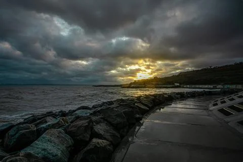 Dramatic sky over the black sea with waves, clouds and stones Stock Photos
