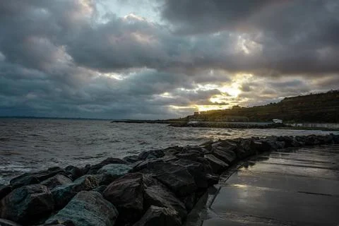 Dramatic sky over the black sea with waves, clouds and stones Stock Photos