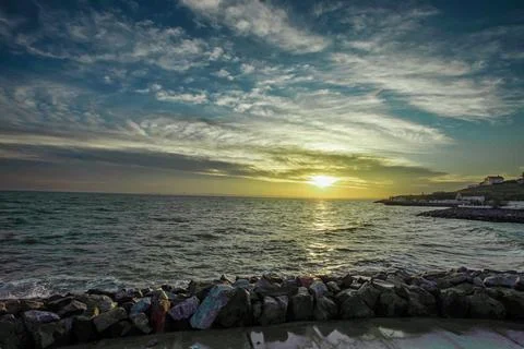Dramatic sky over the black sea with waves, clouds and stones Stock Photos