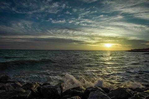 Dramatic sky over the black sea with waves, clouds and stones Stock Photos