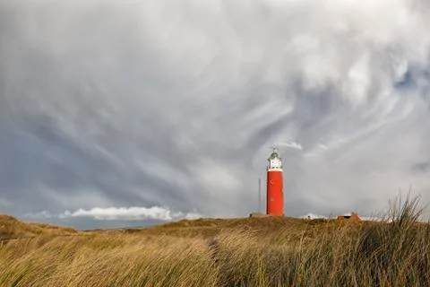 Dramatic sky over ed lighthouse on hill Stock Photos