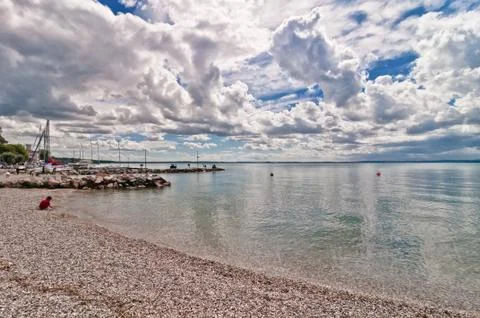 Dramatic sky over Garda lake with pole - Italy Stock Photos
