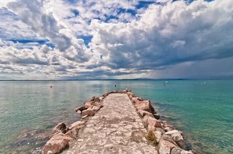 Dramatic sky over Garda lake with pole - Italy Stock Photos