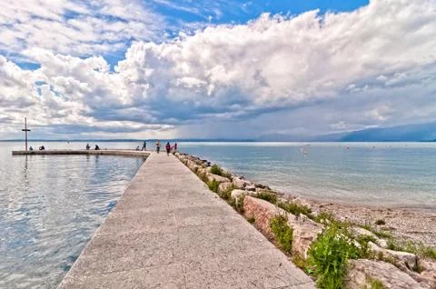 Dramatic sky over Garda lake with pier - Italy Stock Photos