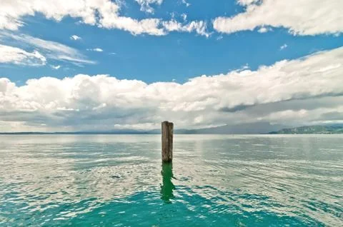 Dramatic sky over Garda lake with pole - Italy Stock Photos