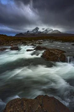 Dramatic sky over large mountains from the River Sligachan on the Isle of Sky Stock Photos