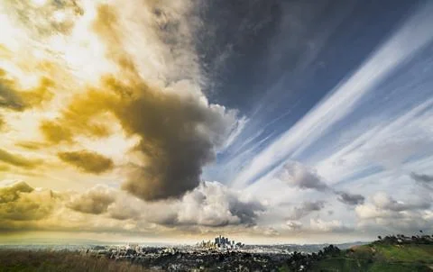 Dramatic sky over Los Angeles cityscape with golden and blue clouds 스톡 사진