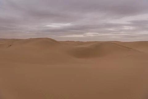 Dramatic sky over the never-ending sand dunes of Gobi desert in Inner Mongoli Stock Photos