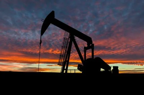 Dramatic Sky Over Pumpjack Silhouette in Rural Alberta, Canada Stock Photos