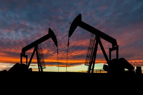 Dramatic Sky Over Pumpjack Silhouettes Stock Photos