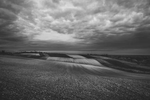 Dramatic sky over rolling fields at dusk Stock Photos