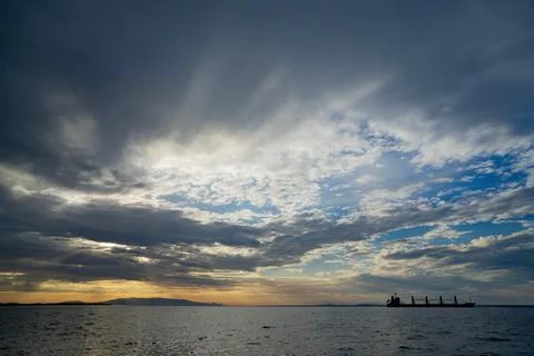 Dramatic Sky Over Sea with Cargo Ship Silhouette Foto stock