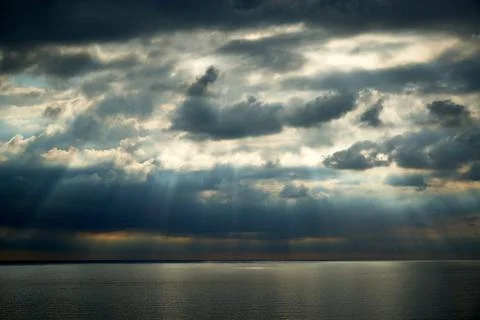 A dramatic sky over the sea with rays of light coming through the clouds Foto stock