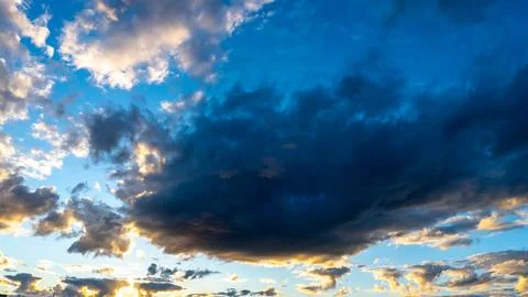 Dramatic sky painted with deep blue and soft golden light Stock Photos