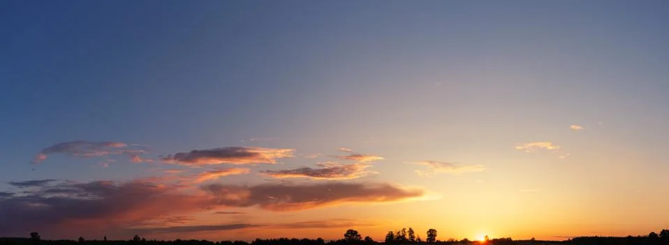 Dramatic sky panorama with clouds at sunset. Stock Photos