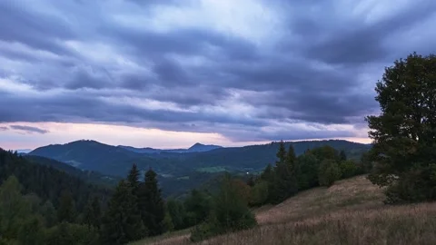 Dramatic sky with rain clouds on the horizon at dusk over a forest landscape on 動画素材 211864891