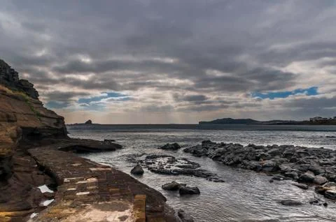 Dramatic sky with ray of light through thick cloud at Yongmoeri Hyean, jeju Foto stock