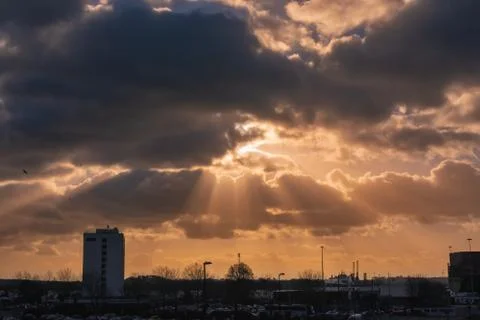 Dramatic sky with rays of sun over city Stock Photos