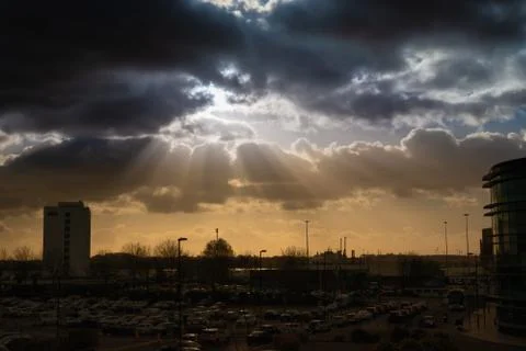 Dramatic sky with rays of sun over city Stock Photos
