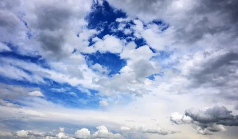 Dramatic sky scene with mixed white and gray clouds over blue Photos