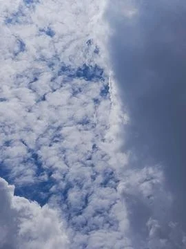 Dramatic sky showing dark storm clouds moving in to cover bright white clouds 库存照片