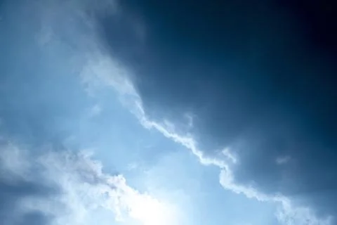Dramatic sky showing dark storm clouds contrasting with bright sunlight break Stock Photos