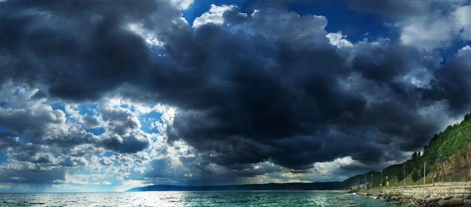 Dramatic sky with stormy clouds and rain over the lake Stock Photos
