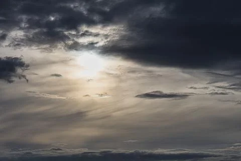 Dramatic sky with sun breaking through dark storm clouds Stock Photos