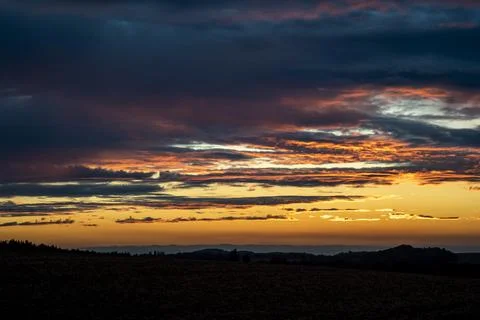 Dramatic sky at sunset. Grey-orange clouds in a blue-yellow sky. Stock Photos