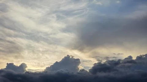Dramatic sky at sunset with heavy dark cumulus clouds at the bottom and lig.. Stock Photos