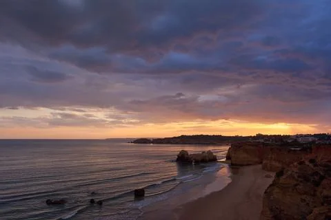 Dramatic sky at sunset over the Atlantic Ocean. Praia dos Careanos in Algarve Stock Photos