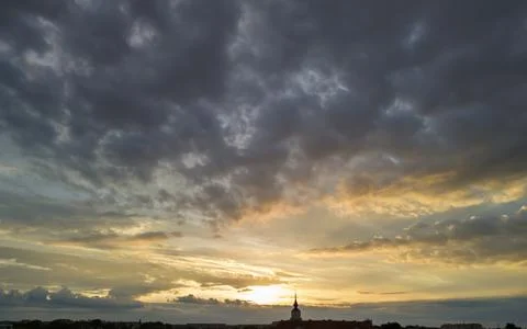 Dramatic sky at sunset with swirling clouds and warm hues, creating an Foto stock