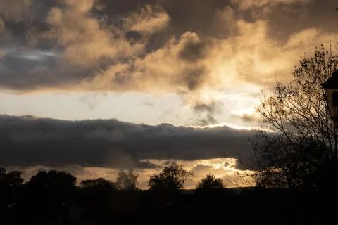 Dramatic sky at sunset with trees silhouetted Foto stock