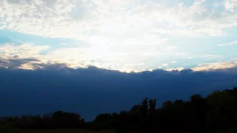 A dramatic sky at sunset where a dark storm front meets bright clouds Stock Footage 316704594