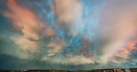Dramatic sky with thunderclouds. Pink Clouds Illuminated by the Rays of sunse Stock Photos