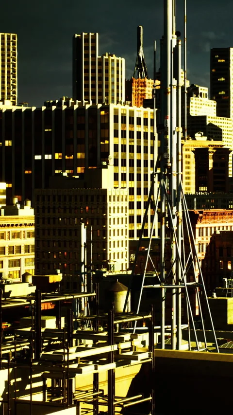 Dramatic skyline with shadows and light over urban construction at sunset Stock Footage 334244675