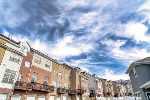 Dramatic skyscape of cloudy blue sky over townhouses with Wasatch mountain view Stock Photos