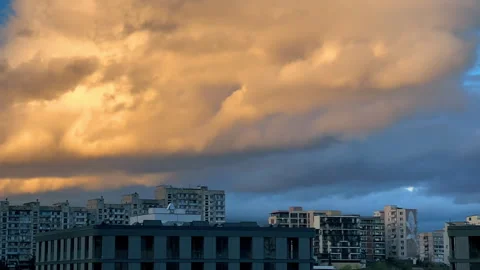 Dramatic skyscape timelaps. Sunset clouds fast running over city rooftops Stock Footage 265128638