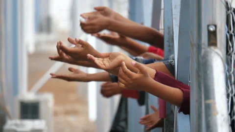 Dramatic Slow motion of children's hands through the fence. Refugee camp, Mosul. Vídeo Stock 158380169