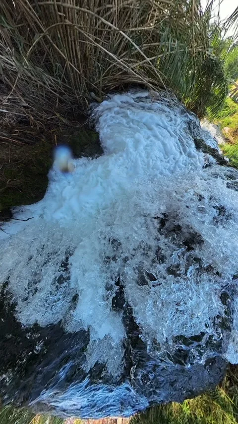 Dramatic slow-motion close-up of a rushing waterfall tumbling over dark rocks, 스톡 동영상 291392904