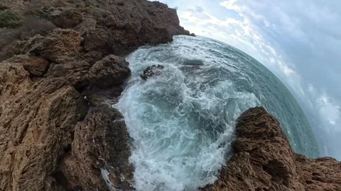 A dramatic slow-motion shot with a tiny planet effect of waves crashing into Stock Footage 293683834