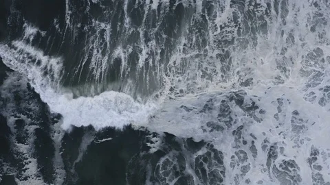 Dramatic slow-motion waves crash to shore after storm, top down aerial Stock Footage 112703373