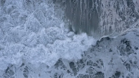 Dramatic slow-motion whitewater waves churn ocean after storm, top down aerial Stock Footage 112704226