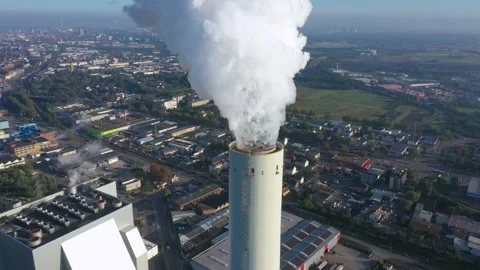 Dramatic smoke from a chimney, an industrial plant in city aerial view. Stock Footage 242328562