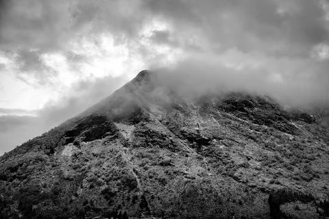 Dramatic Snow Covered Mountain Peak in Fog in Black and White. Stock Photos
