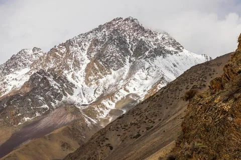 Dramatic snow-covered mountains in vast cold landscape at springtime day 库存照片