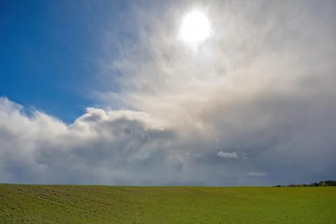 Dramatic spring sky over green field 스톡 사진