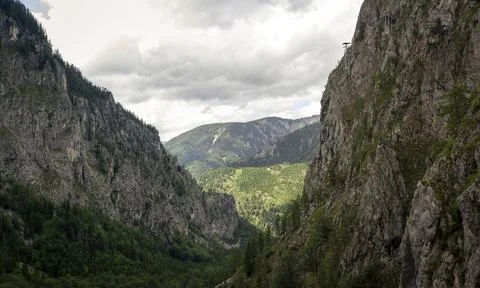 Dramatic Steep Limestone Cliffs Framing Deep Forested Alpine Valley Beneath.. Stock-Fotos