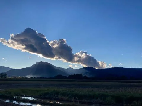 Dramatic storm cloud illuminating over Pyrenees mountains at sunset Stock Photos